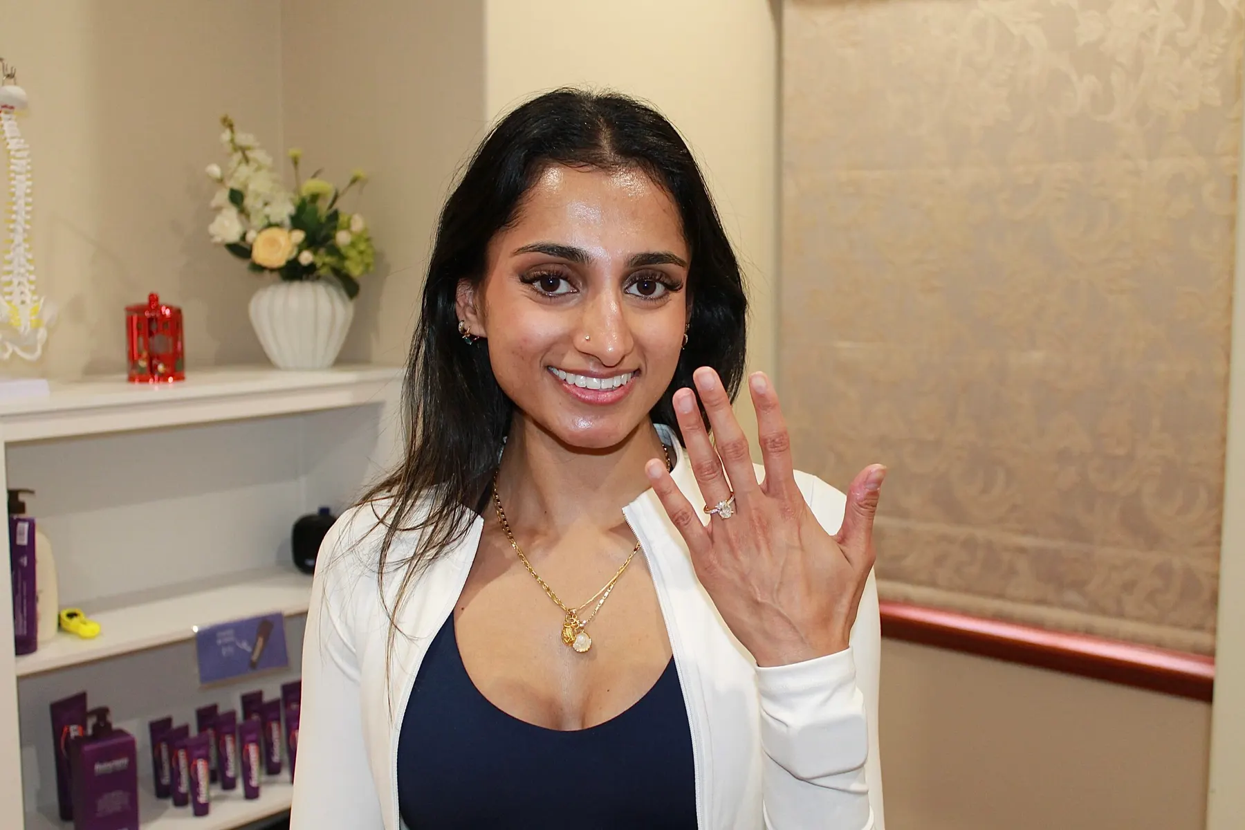 A smiling bride-to-be in the clinic showing her engagement ring
