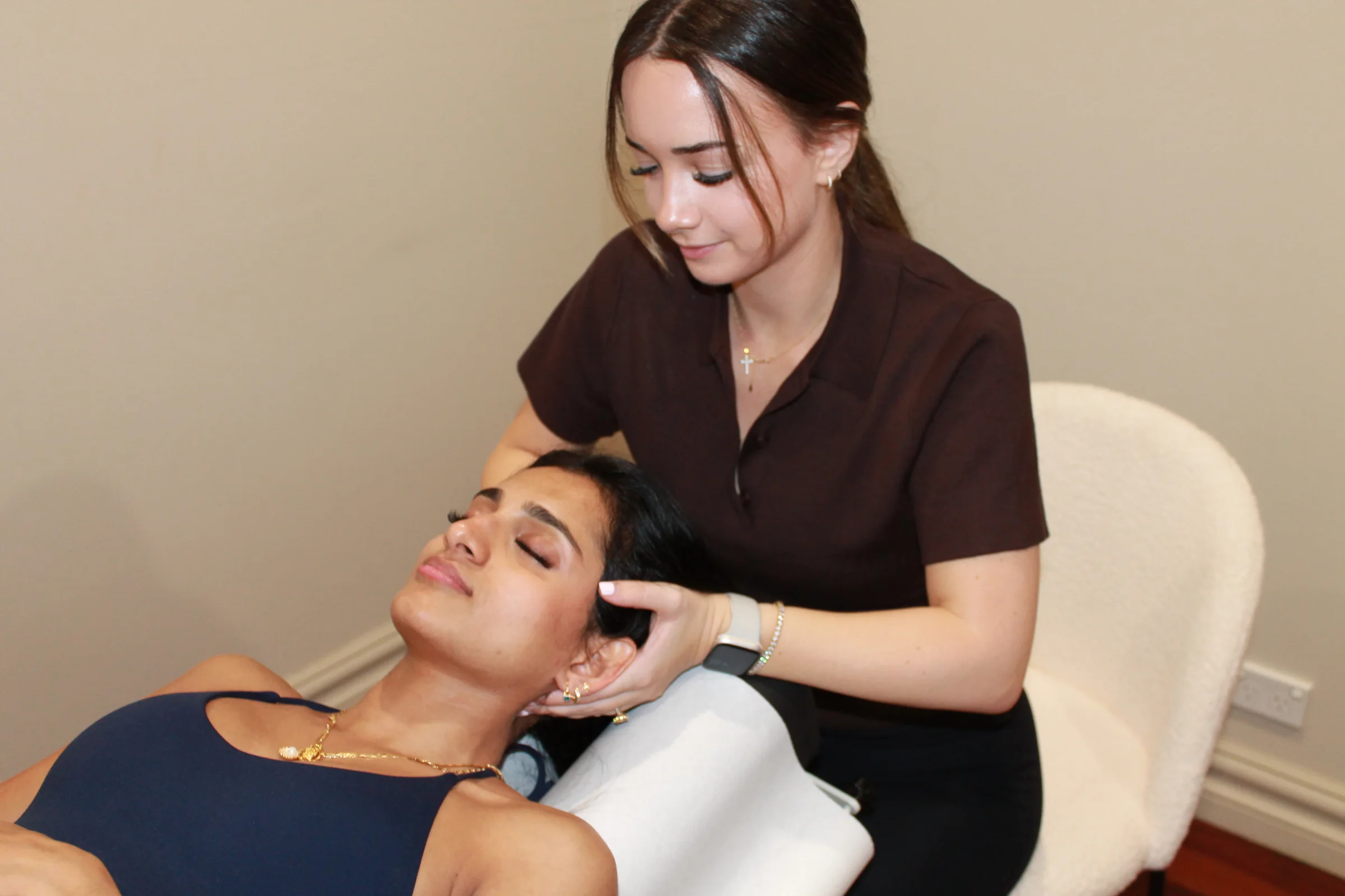 Alicia Neil performing a gentle neck treatment on a reclined patient